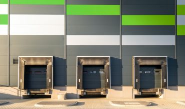 Cargo loading dock doors of big warehouse building, outdoor